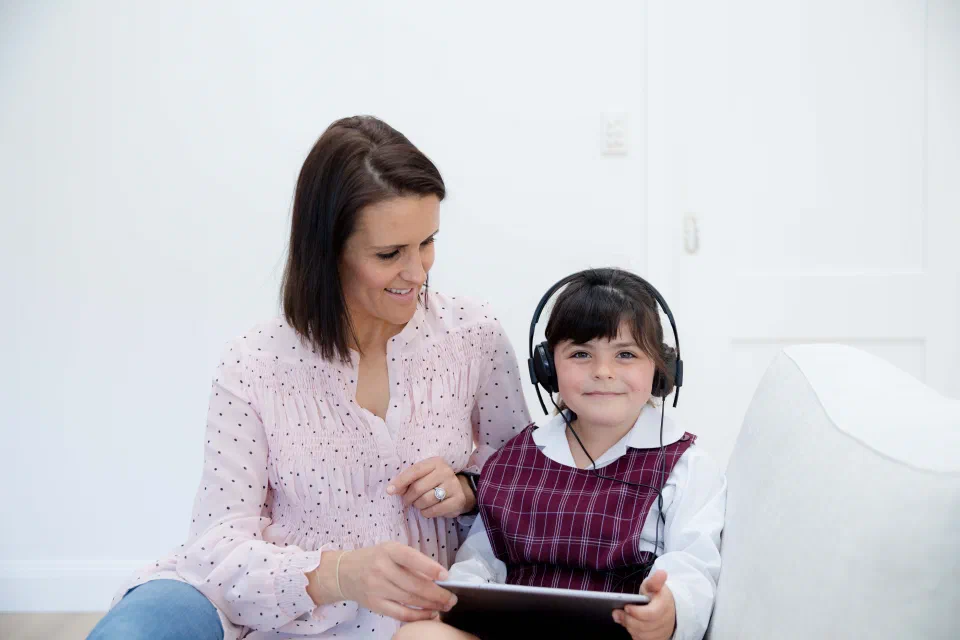 Child wearing headphones taking the Sound Scouts hearing test on a tablet
