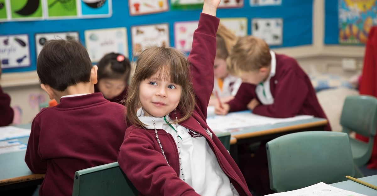 Girl raising her hand in the classroom