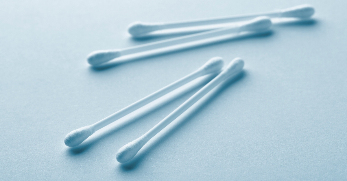 Four cotton buds on white surface